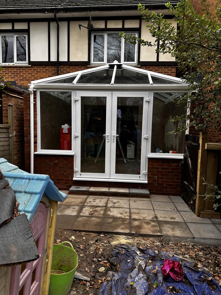 White uPVC conservatory built by Dukes London on the rear of a Hendon HA3 property — fully glazed with French doors and pitched roof