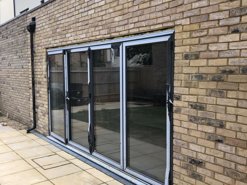 Four-panel aluminium bifold doors installed by Dukes London on a Cheshunt EN8 rear extension — replacing a single door for full garden access