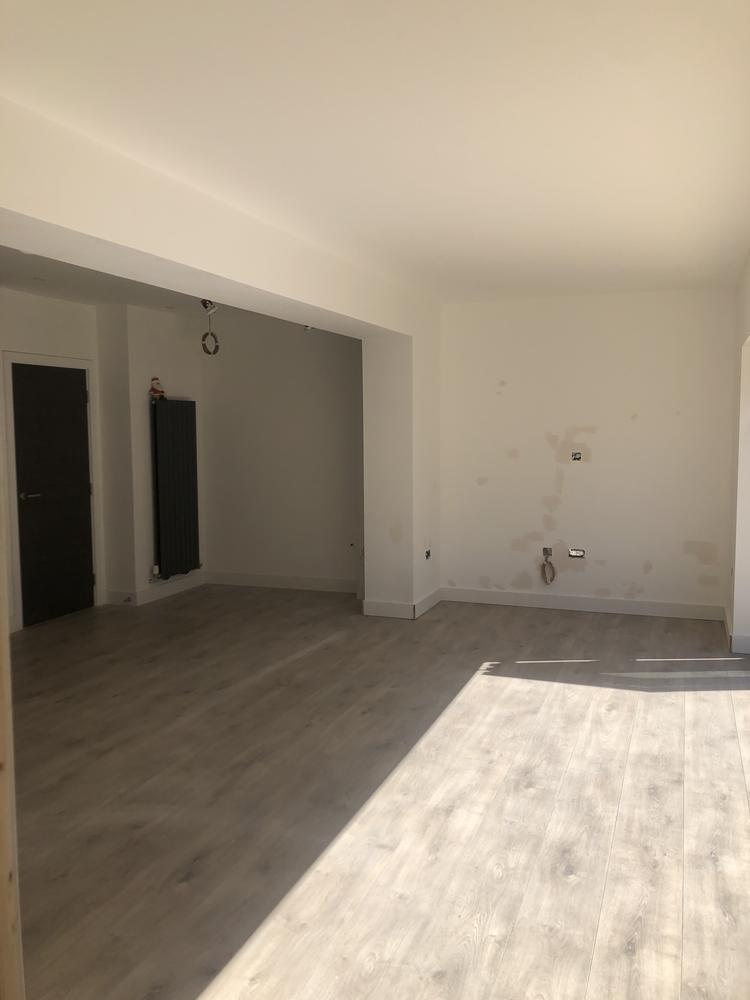 Interior fit-out by Dukes London — clean white plasterwork and wood-effect flooring inside a Cheshunt EN8 home extension